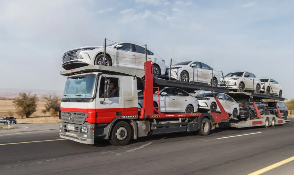 open car transport trailer carrying multiple vehicles on highway